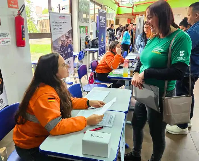 Imagem de participantes da feira reailzando inscrição.